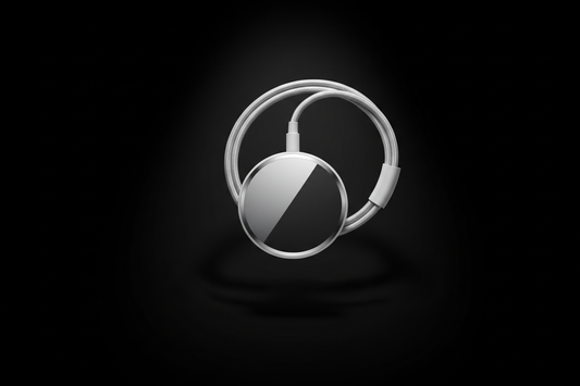 Ultra-realistic Apple product render of a MagSafe charging cable in the same visual style as the official AirPods Pro marketing images. Pure black background, dramatic centered spotlight from above, glossy reflections, premium metallic highlights, soft shadows, floating composition, highly polished surfaces, minimalistic Apple aesthetic, no text, no branding aside from the product itself. MagSafe puck facing forward, cable gently curved behind it.Ultra-realistic Apple product render of a MagSafe charger